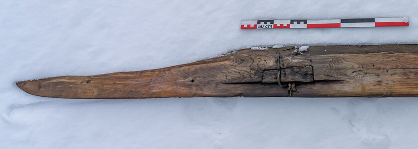 Oversiden av skia med tuppen til høyre. En liten del av skia mangler på venstresiden bak. Skia er 187 cm lang og 17 cm på det bredeste. Skia har opphevet fotsteg med bevart binding.  - Klikk for stort bilde