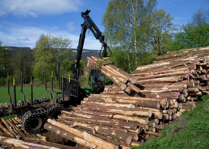 Skogbruksmaskin stabler tømmer - Klikk for stort bilde