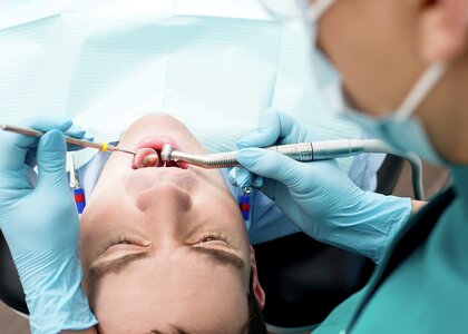Tannlege undersøker munnen til en ung pasient. - Klikk for stort bilde